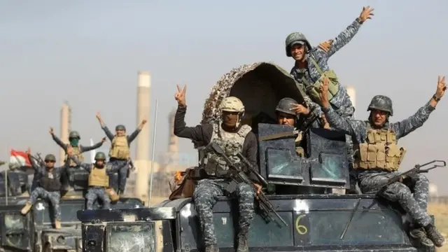 Iraqi forces flash a victory sign while driving past an oil production plant near Kirkuk. Photo: 16 October 2017