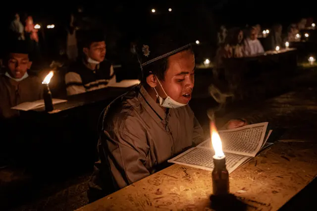 MAY 02: Students read the Quran by candlelight during ritual Nuzulul Quran and Laylat al-Qadr (Night of Destiny) which marks the night in which the holy Quran was first revealed to the Prophet Mohammed at the Nurul Hidayah Al-Mubarokah boarding school on May 2, 2021 in Boyolali, Central Java, Indonesia. Laylat al-Qadr is was one of the odd-numbered nights of the last ten days of Ramadan. Ramadan, the ninth month of the Islamic calendar is a month of fasting, prayers and recitation of the Quran. (Photo by Ulet Ifansasti/Getty Images)