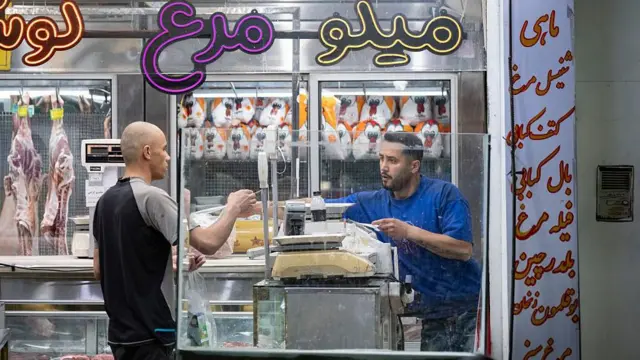 مردی ایرانی در حال خرید گوشت از یک قصابی در مرکز شهر تهران، ایران، در ۱۱ آوریل ۲۰۲۶ (۲۲ فروردین ۱۴۰۵)، همزمان با برگزاری مذاکرات مستقیم ایران و ایالات متحده در اسلامآباد پاکستان، دیده میشود.