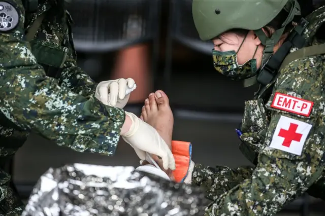 过去汉光演习一名女兵在演练包紮伤患。