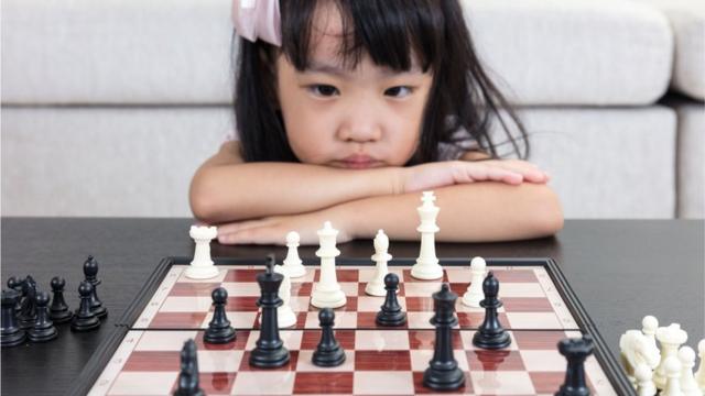 一名女童注視著棋盤