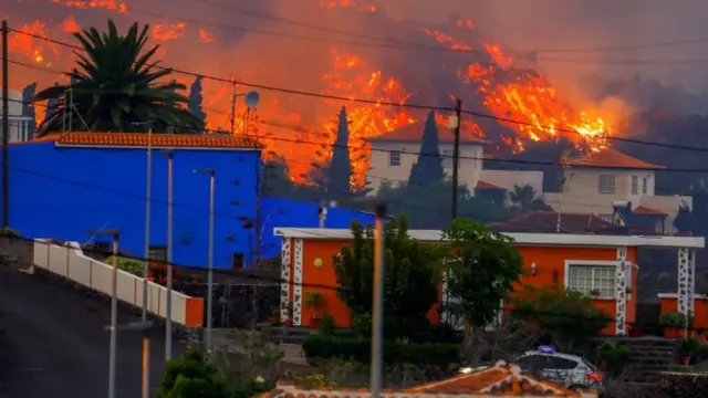 La lava fluye detrás de las casas en Canarias, España.