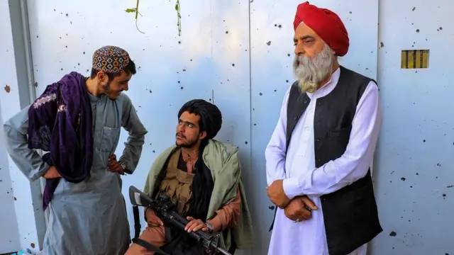 काबुल गुरुद्वारे पर हमले के बाद तालिबान सुरक्षाकर्मियों के साथ एक सिख श्रद्धालु