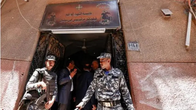 عنصران من قوات الأمن المصرية يحرسان كنيسة "أبي سيفين" التي شب فيها الحريق.