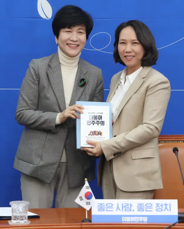 지난해 2월 4.15 총선을 앞두고 서울 여의도 국회에서 열린 더불어민주당 인재영입 발표 기자회견에서 김영주 의원이 16번째 영입인사인 원옥금 이주민센터 동행 대표에게 당헌당규 책자를 전달하고 있다