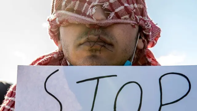 4 Mart 2016'da Calais'de 'Polisi Durdurun' yazan bir kağıt taşıyan 12 İranlı göçmenden biri