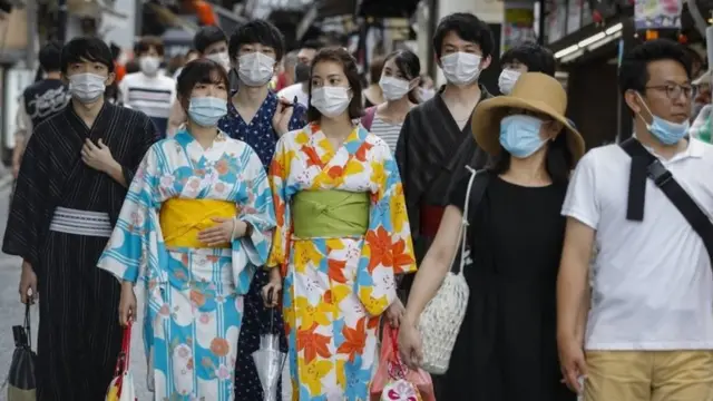 Kimono-clad women wearing protective face masks walk near Kiyomizudera temple in Kyoto, Japan, 23 July 2020