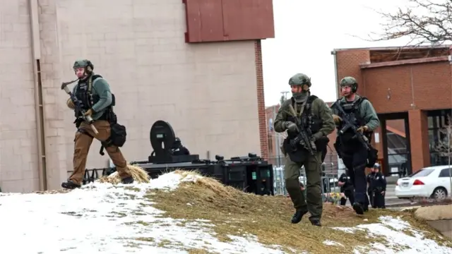 Law enforcement officers sweep the area outside of a King Soopers grocery store, which was the site of a shooting in Boulder, Colorado