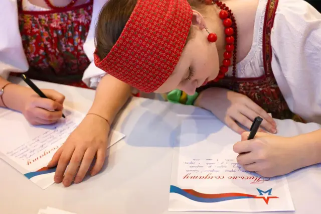 Участницы фестиваля «Мы Россия — мы вместе!» во время праздничных мероприятий в День народного единства в Государственном концертном зале имени А. М. Каца пишут письмо российским военным