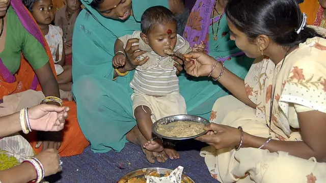 చిన్నారికి అన్నం తినిపిస్తున్న అంగన్ వాడీ కార్యకర్త