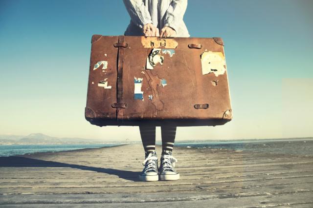 Stock image of young woman with a suitcase