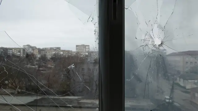 Ventana rota por un proyectil en una clínica