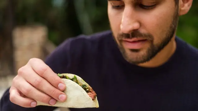 Joven comiendo tacos