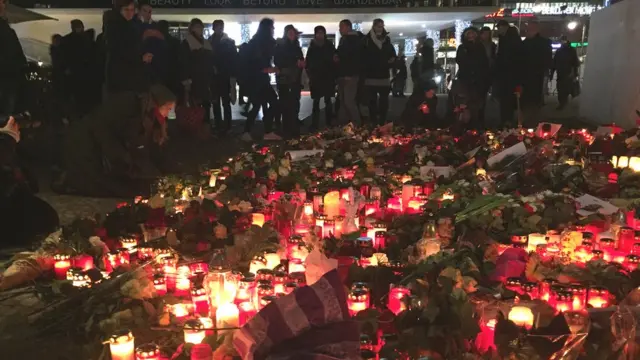 Свечи и цветы на месте на рождественской ярмарке, протараненной грузовиком в Берлине