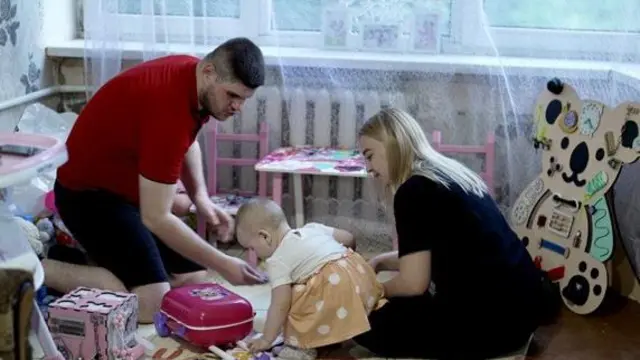 Viktoria (kulia) akiwa na mume wake Serhiy na binti yao Eva kwenye gorofa yao huko Pokrovsk