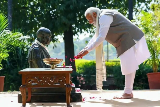 ਨਰਿੰਦਰ ਮੋਦੀ ਗਾਂਧੀ ਦੀ ਬਸਟ ਤੇ ਫੁੱਲ੍ਹ ਚੜ੍ਹਾਉਂਦੇ ਹੋਏ