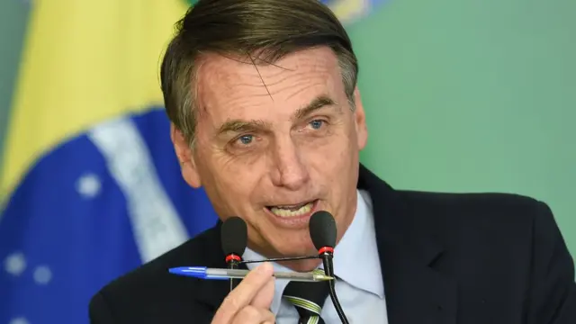 Bolsinaro com caneta na mão