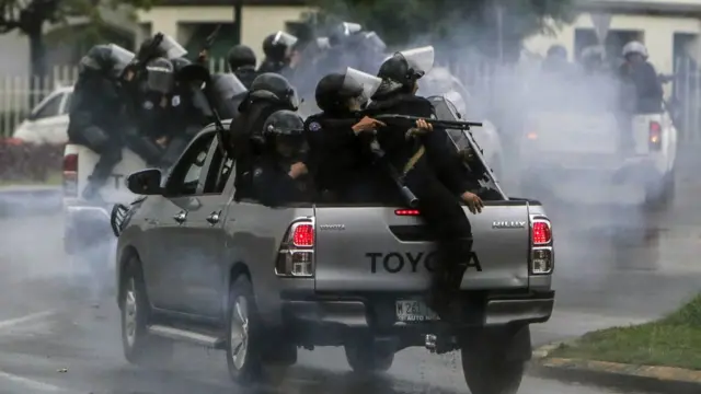 Policías con armas en una camioneta