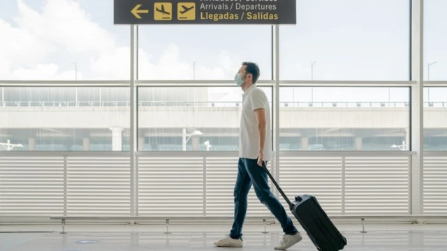 Homem carrega mala por aeroporto