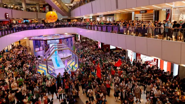 Fans of Hong Kong swimmer Siobhan Haughey watch the live broadcast of the Tokyo 2020 Olympic Summer Games women"s 100m freestyle final at a shopping mall in Hong Kong, China July 30, 2021.