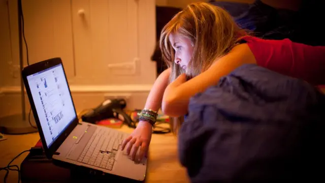 Mulher usando laptop na cama