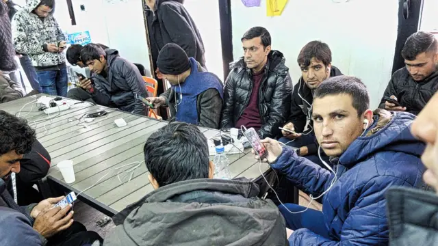 Des migrants utilisent le wifi pour accéder à Internet