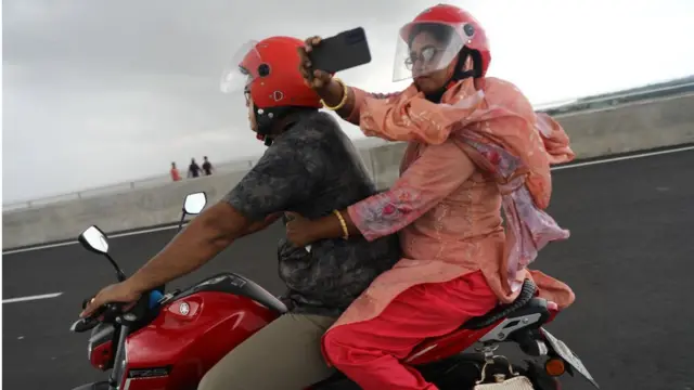 পদ্মা সেতুতে চলন্ত মোটর সাইকেল থেকে একজন আরোহী মোবাইল ফোন ক্যামেরায় ভিডিও করছেন, ২৬/০৬/২০২২