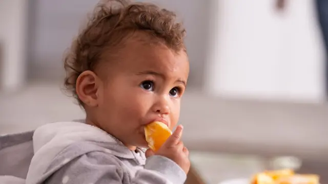 enfant mangeant une orange