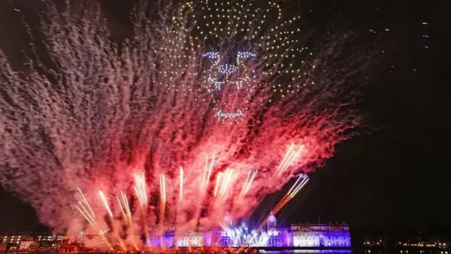 Drones and fireworks illuminate the night sky over the Old Royal Naval College in Greenwich