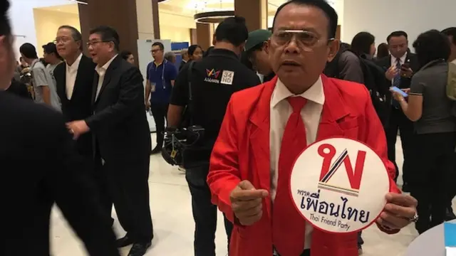 แกนนำพรรคเพื่อนไทยซึ่งบอกว่าเป็น “คนเสื้อแดงตัวจริง” อธิบายที่มาของชื่อพรรค หลังรักษาการเลขาธิการพรรคเพื่อไทย (ยืนอยู่ข้างหลัง) ออกมาวิจารณ์ว่าอาจทำให้ประชาชนสับสนเข้าใจผิด