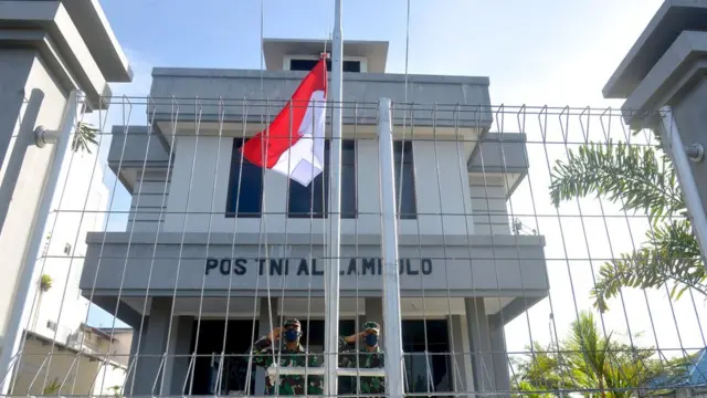 Prajurit TNI AL memberikan penghormatan saat pengibaran bendera merah putih setengah tiang di Pos Keamanan Pelabuhan Perikanan Lampulo, Banda Aceh, Aceh, Selasa (27/04).