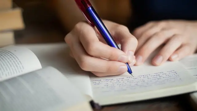 Студент делает заметки в тетради