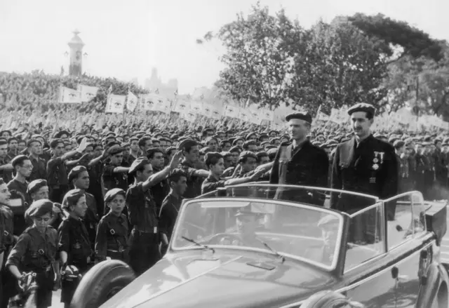 En 1937 el cuñado del general Francisco Franco y ministro del Interior de España, Ramón Serrano Suner, llega en coche a Valencia junto al gobernador provincial para una ceremonia.