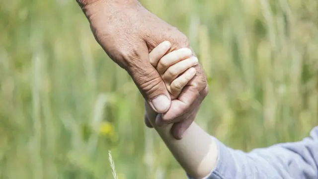 Un adulto da la mano a un niño