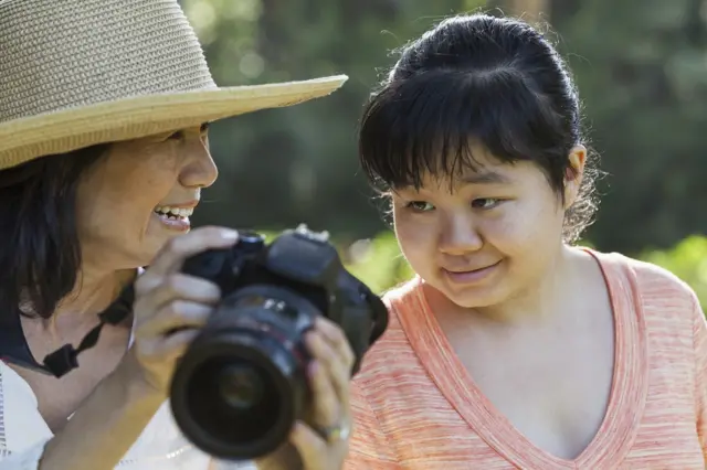 Mulher mostra foto para filha com autismo