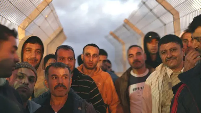 Trabajadores palestinos esperan pasar un puesto de control