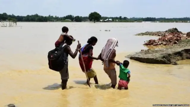 வெள்ளத்தால் இடம் பெயரும் குடும்பம் ஒன்று.