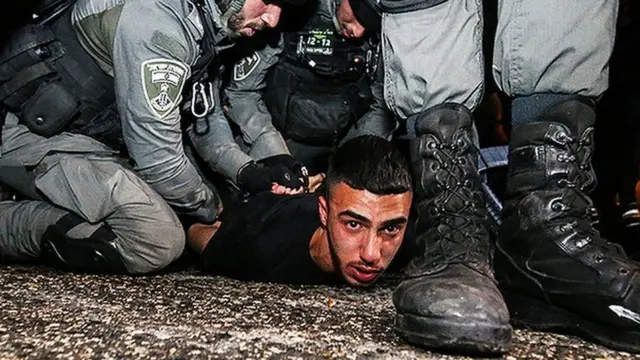 Jovem palestino sendo preso pela polícia israelense