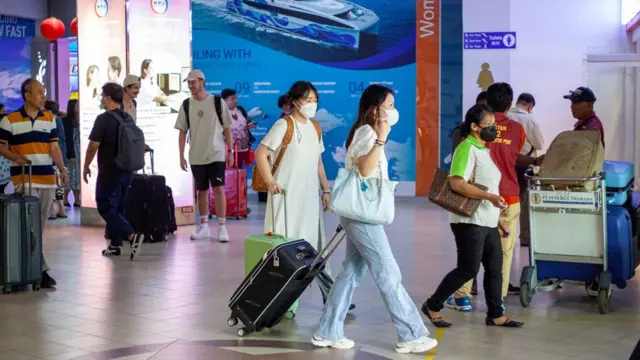 Sejumlah penumpang berjalan keluar dari Pelabuhan Internasional Batam Centre, Batam, Kepulauan Riau, Sabtu (21/1/2023)