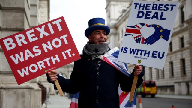 Протестующий в Лондоне с плакатами "Брексит того не стоил". "Лучшая сделка - внутри ЕС".