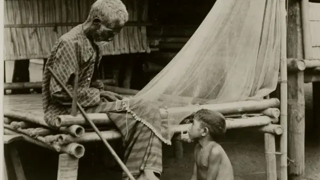 Seorang nelayan mengikat jaring ikan bersama anaknya di Pulau Flores.