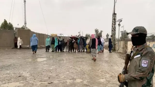 पाकिस्तान और अफ़ग़ानिस्तान के बीच चमन बॉर्डर पर खड़े लोग और सुरक्षाकर्मी