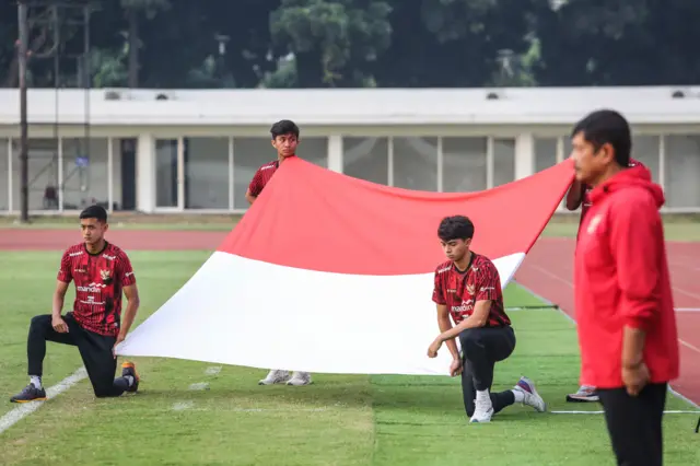 Pesepak bola Timnas U-20 mengibarkan bendera merah putih saat upacara di Stadion Madya, Kompleks GBK, Jakarta, Sabtu (17/8/2024).