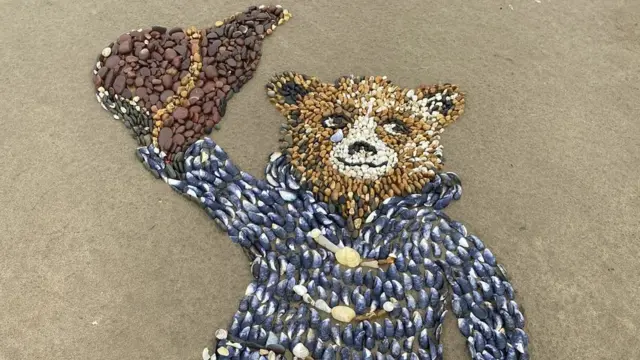 Family create Paddington Bear beach art for Queen - BBC News