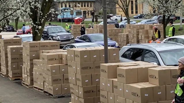 Carros em fila para distribuição de alimentos