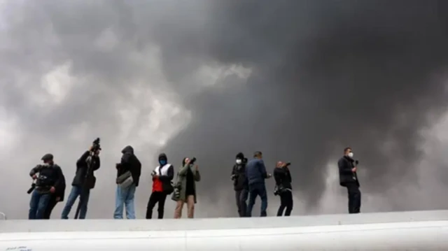 تہران کے شمال مغرب میں واقع شاہران آئل ریفائنری کے نزدیک میڈیا کے نمئندے کھڑے ہیں۔