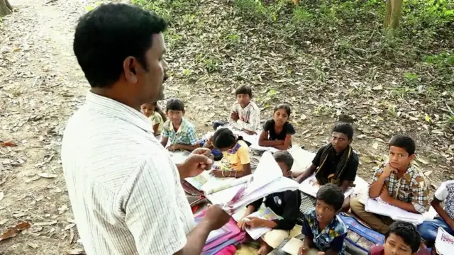 చెట్టు కింద పాఠాలు చెబుతున్న టీచర్