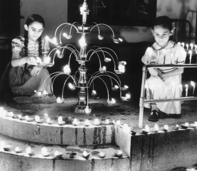 1957માં લેવાયેલી તસવીરમાં દિવાળીના દિવસે દીવા પ્રગટાવી રહેલી બે બાળકીઓ