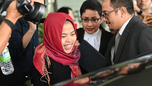 Siti Aisyah surrounded by reporters