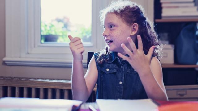 Un niña cuenta con los dedos de la mano.
